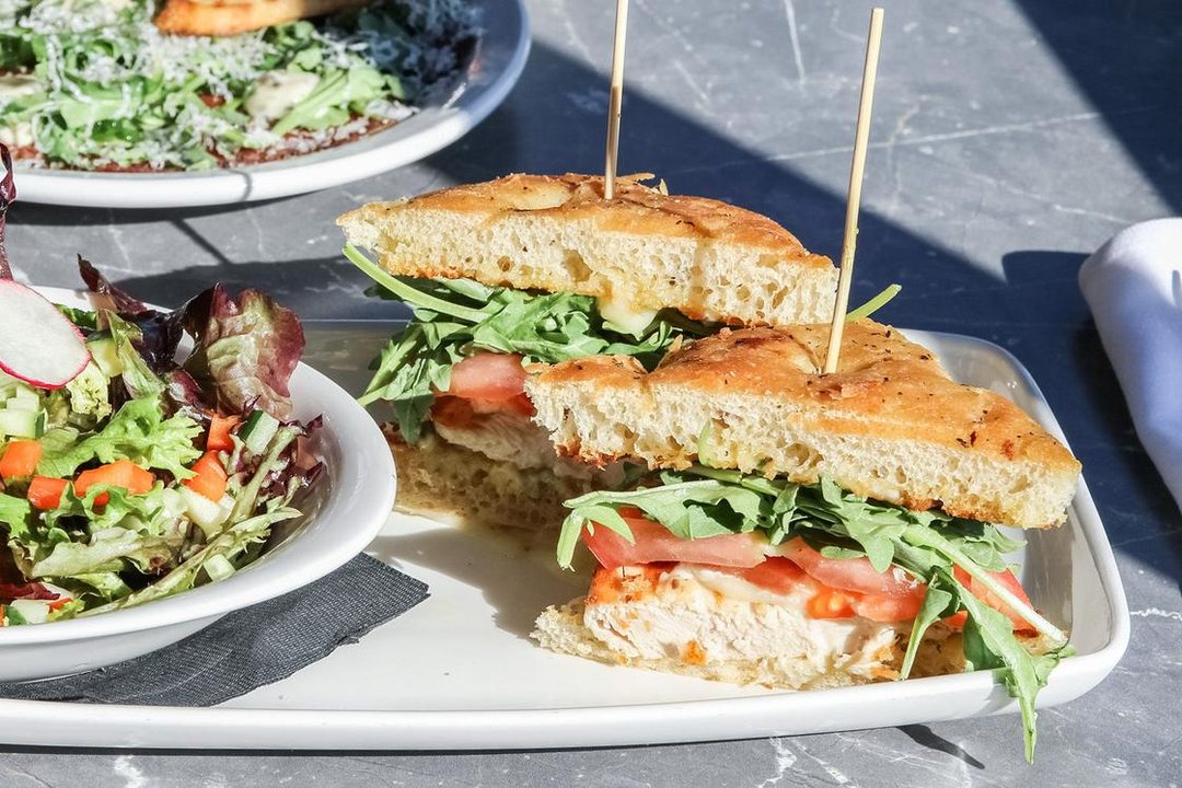 Chicken focaccia sandwich with a side salad served on the patio at Kingfishers in Maple Ridge