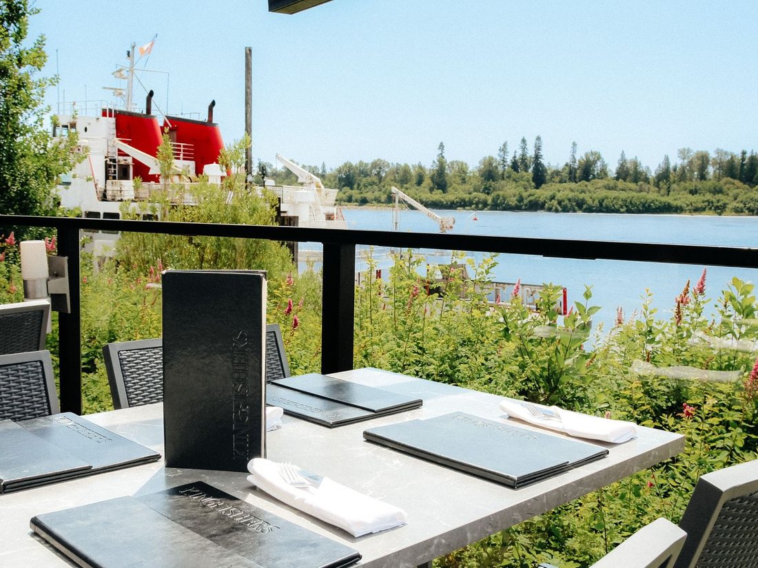 Set table on the riverside patio at Kingfishers looking out over the Fraser River