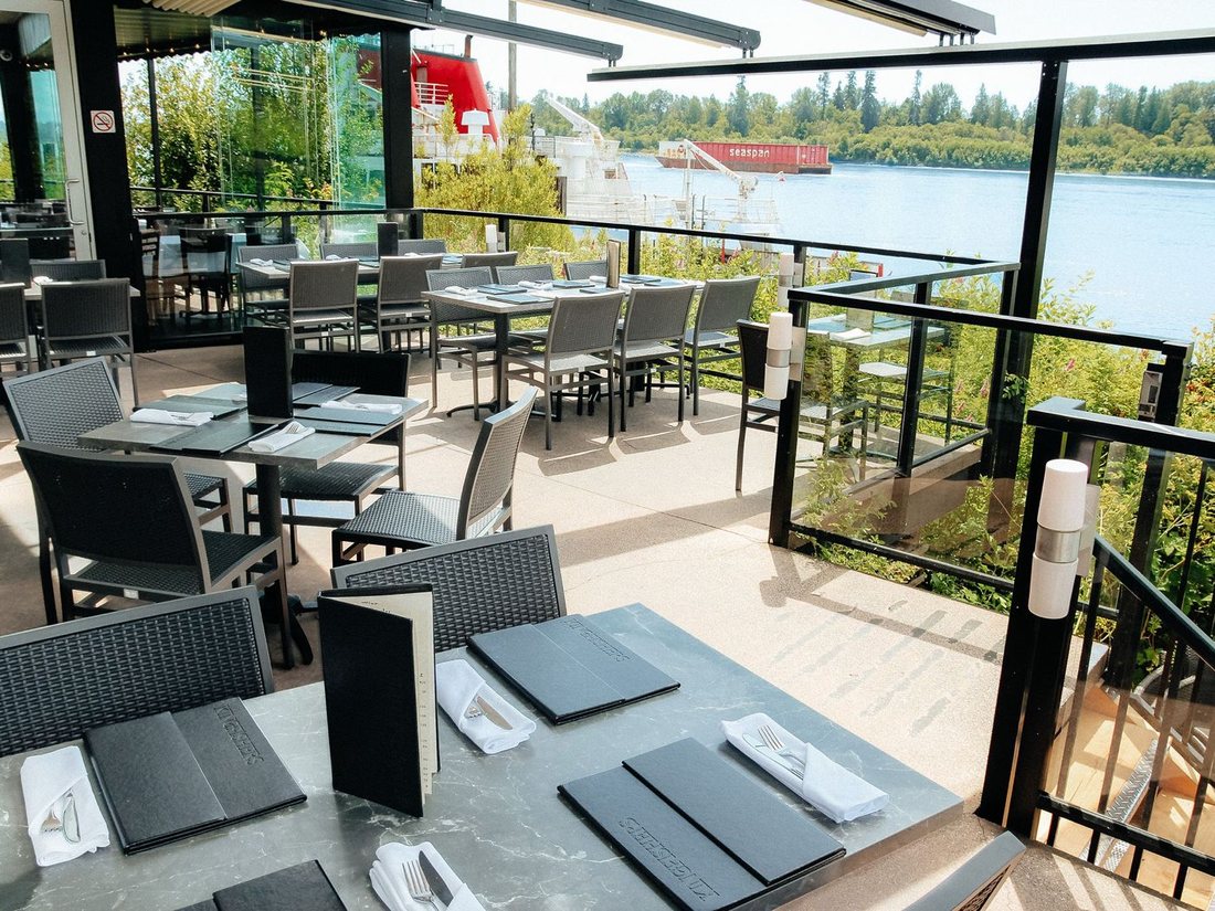 Covered patio seating beside the Fraser River at Kingfishers in Maple Ridge
